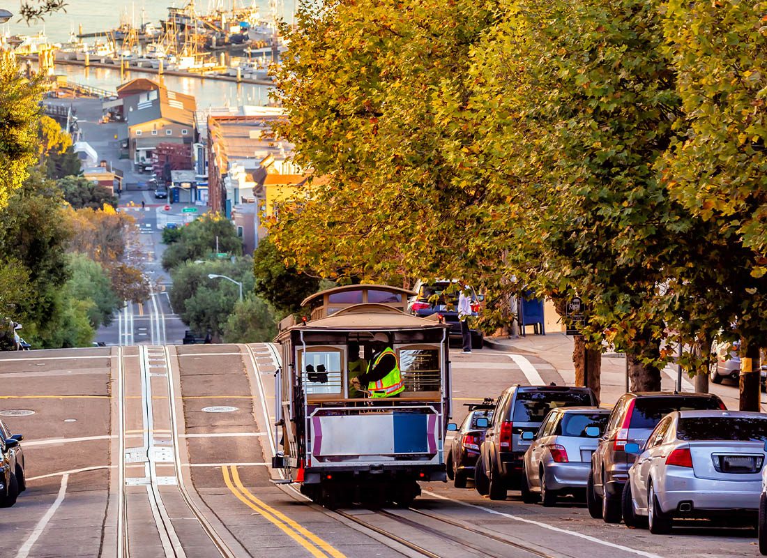 About Our Agency - Steep Hills Of San Francisco, California With Trolley and Bay in the Distance